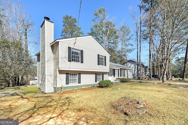 view of front of house with a chimney and a front lawn