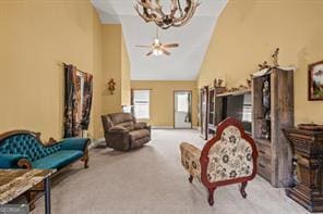 living room featuring carpet, high vaulted ceiling, and ceiling fan with notable chandelier