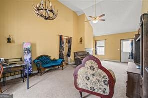 living area featuring carpet floors, high vaulted ceiling, and ceiling fan with notable chandelier