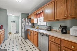 kitchen featuring a sink, light countertops, brown cabinets, and stainless steel appliances