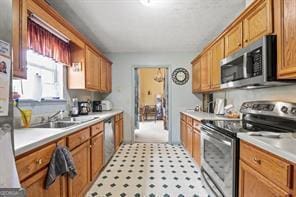 kitchen featuring light countertops, brown cabinets, appliances with stainless steel finishes, and a sink