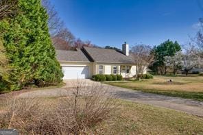 ranch-style home featuring a garage, driveway, and a front yard