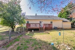 back of house with a deck, a yard, fence, and central AC