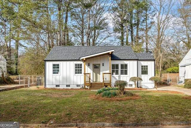 view of front of home with crawl space, a front yard, board and batten siding, and fence