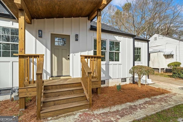 doorway to property with a shingled roof, crawl space, and board and batten siding