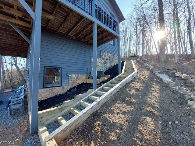 view of home's exterior featuring stone siding and central AC unit