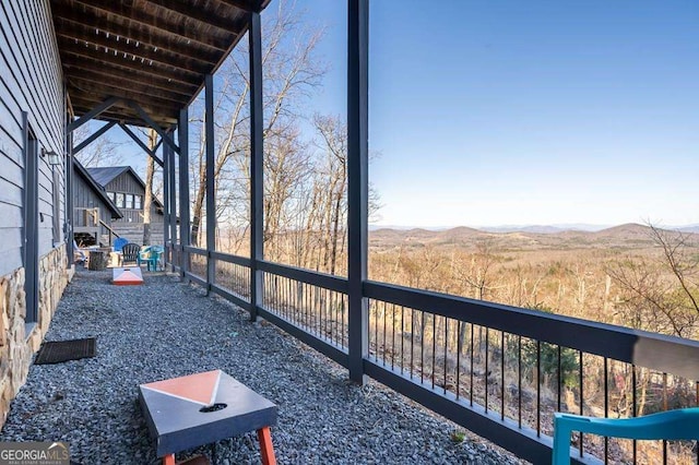 exterior space featuring wood ceiling, beamed ceiling, and a mountain view