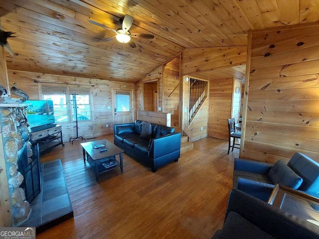 living area with stairs, wood walls, and wood ceiling