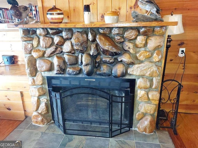 details featuring a stone fireplace and wood walls