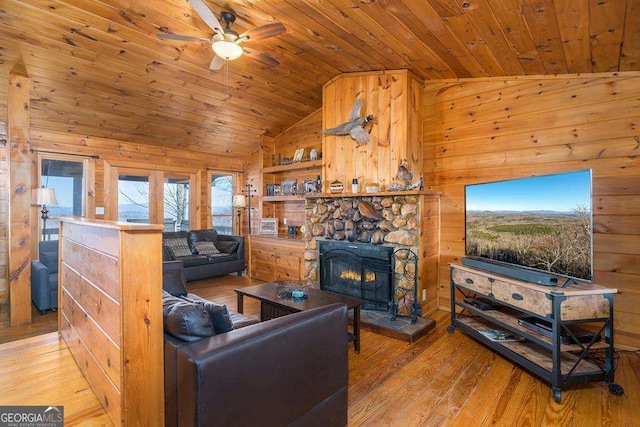 living area featuring light wood-type flooring, wood ceiling, and wooden walls