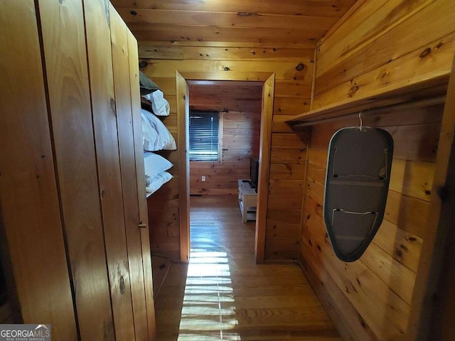 hall with wood walls and light wood finished floors