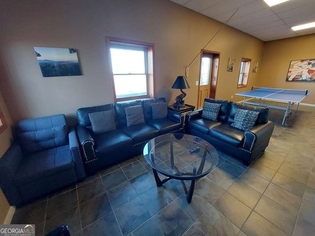 living room featuring a drop ceiling and tile patterned floors