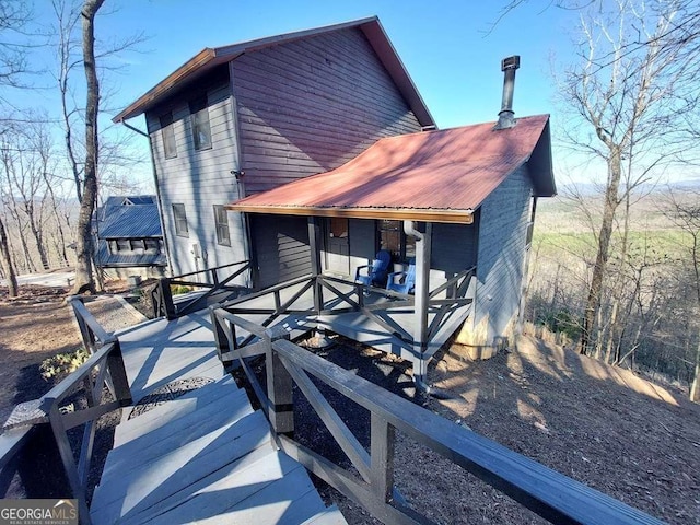 back of house with a deck and metal roof