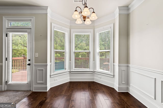 interior space with dark wood-style floors, ornamental molding, a notable chandelier, and a wainscoted wall