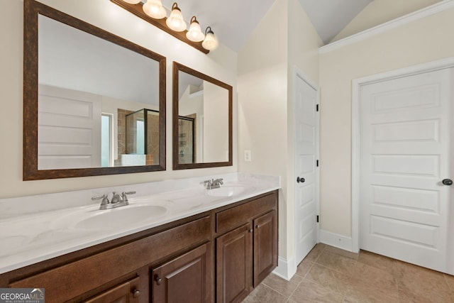 bathroom with a stall shower, lofted ceiling, a sink, and double vanity