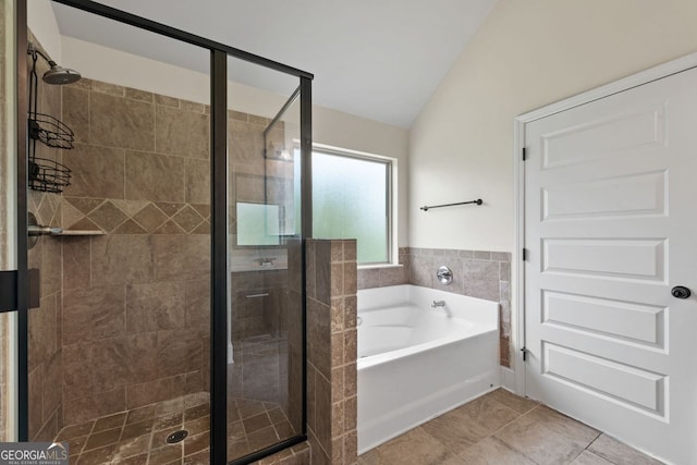 bathroom with lofted ceiling, a garden tub, tile patterned flooring, and a stall shower