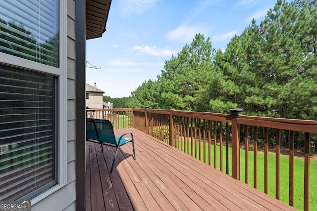 wooden terrace featuring a yard