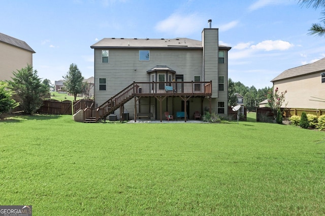 rear view of house with a patio, stairs, fence, a deck, and a yard