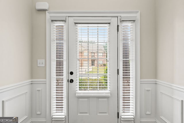 entryway with a wainscoted wall and a decorative wall