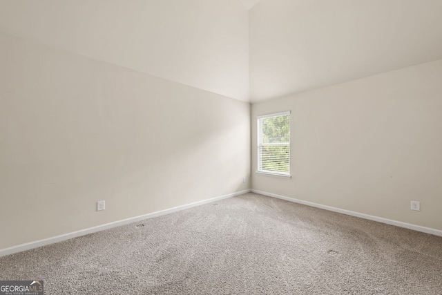 empty room with high vaulted ceiling, carpet, and baseboards