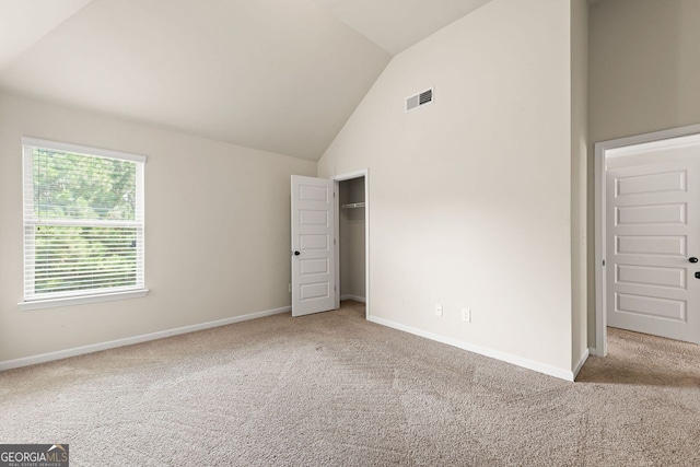 unfurnished bedroom with high vaulted ceiling, carpet flooring, visible vents, baseboards, and a closet