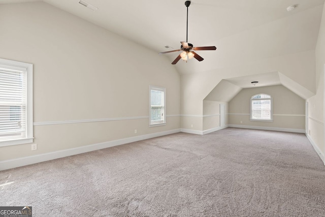 additional living space featuring lofted ceiling, visible vents, baseboards, and light colored carpet