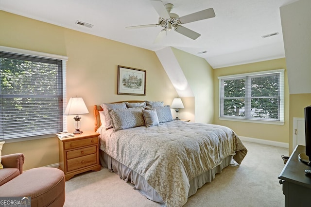 bedroom featuring vaulted ceiling, multiple windows, visible vents, and light colored carpet