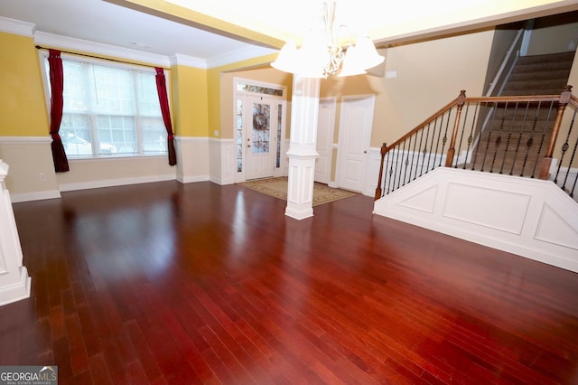 interior space with stairway, wood finished floors, crown molding, ornate columns, and a notable chandelier