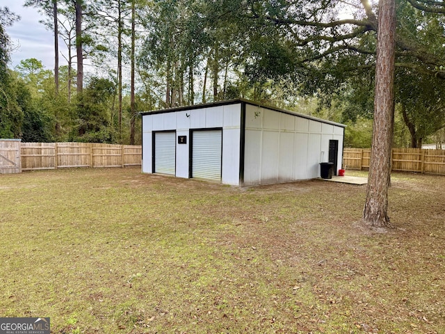 view of outdoor structure featuring fence and an outbuilding