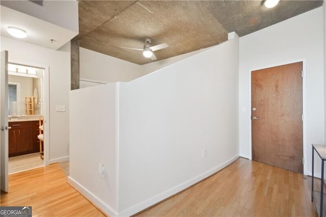 hallway featuring light wood-style floors and baseboards