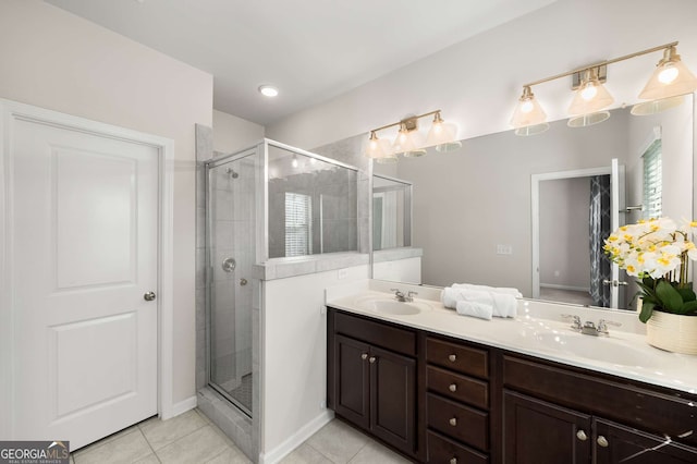 bathroom featuring double vanity, tile patterned floors, a sink, and a shower stall