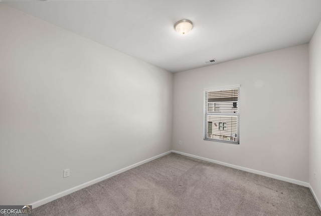 spare room featuring carpet floors, baseboards, and visible vents