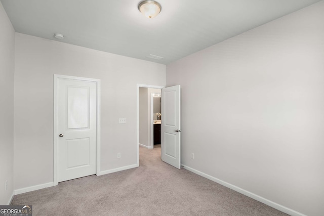 unfurnished bedroom featuring baseboards and light colored carpet