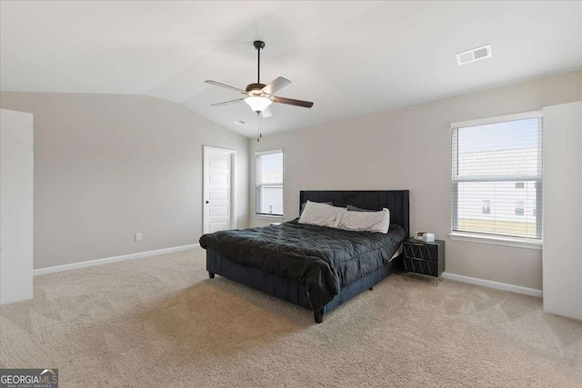 bedroom featuring vaulted ceiling, light carpet, visible vents, and baseboards