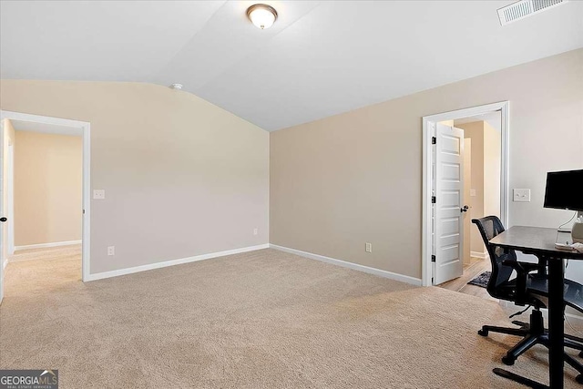 home office with lofted ceiling, baseboards, visible vents, and light colored carpet