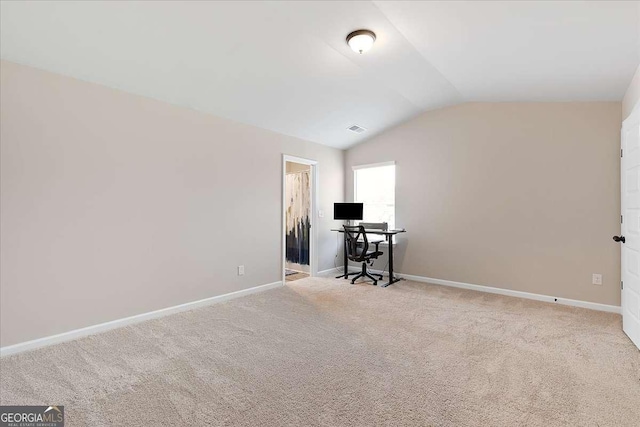 carpeted office with lofted ceiling, visible vents, and baseboards