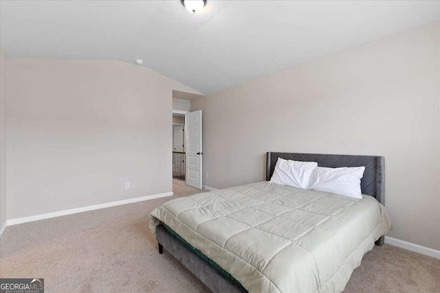 carpeted bedroom with lofted ceiling and baseboards