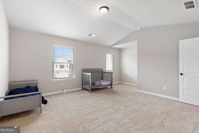 sitting room featuring carpet floors, baseboards, visible vents, and vaulted ceiling