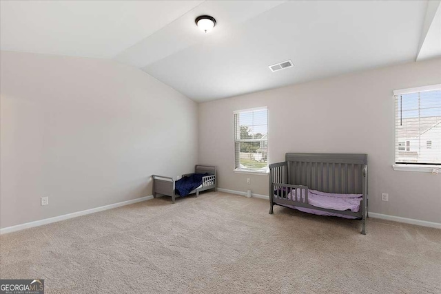 carpeted bedroom with baseboards, visible vents, and vaulted ceiling