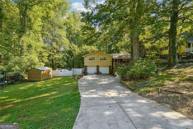 view of front of house with a trampoline, an outbuilding, a front yard, fence, and a garage