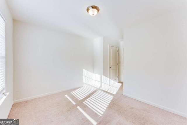 empty room featuring carpet flooring and baseboards