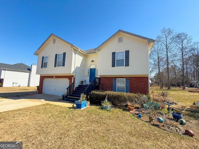 split foyer home with an attached garage, a front yard, concrete driveway, and brick siding