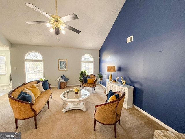 carpeted living area featuring lofted ceiling, a ceiling fan, visible vents, and a textured ceiling