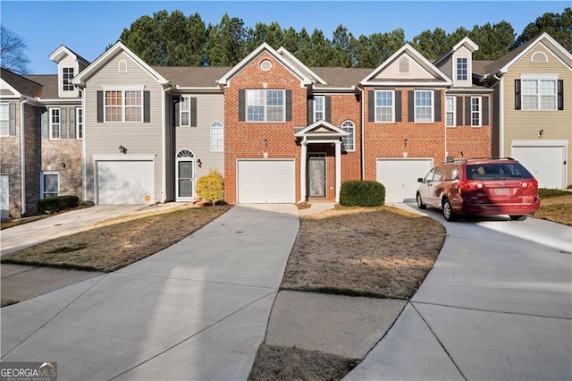 view of property featuring an attached garage, brick siding, and driveway