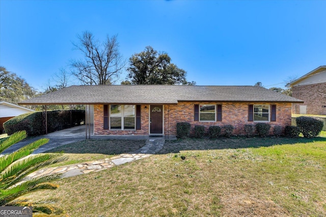 ranch-style house with a shingled roof, a front lawn, a carport, and brick siding