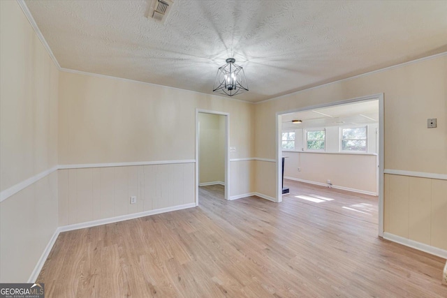 interior space featuring visible vents, a notable chandelier, a textured ceiling, and light wood finished floors