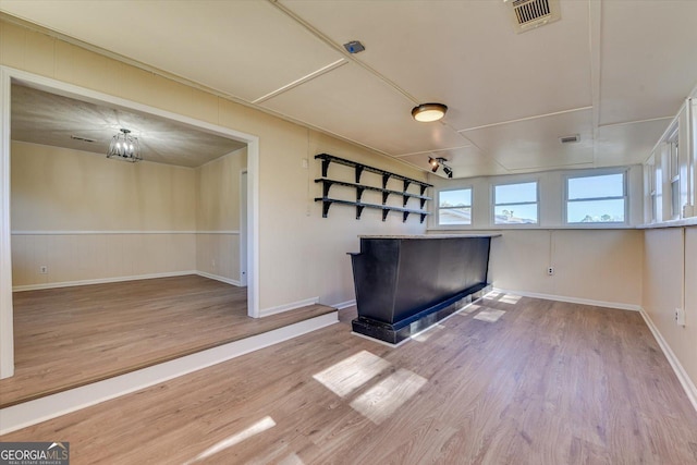 empty room with visible vents, baseboards, and wood finished floors