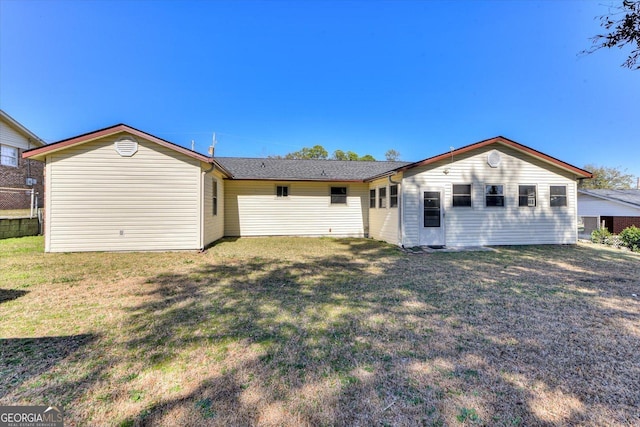 rear view of property featuring a lawn