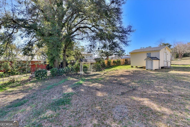 view of yard with an outbuilding, fence, and a storage unit