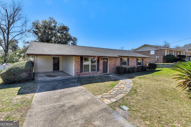 view of front of home with brick siding, roof with shingles, concrete driveway, a carport, and a front lawn